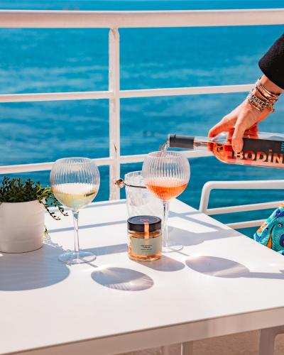 a person pouring a glass of wine on a table on a cruise ship at Hotel de La Plage - Mahogany in Cassis