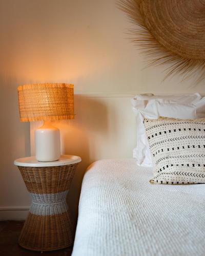 a bedroom with a bed with a lamp and a candle at Hotel de La Plage - Mahogany in Cassis