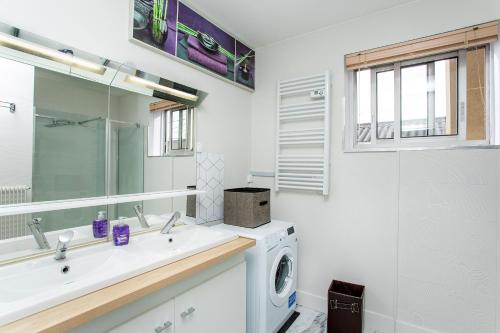 a bathroom with a sink and a washing machine at BLUE HOME in Roanne
