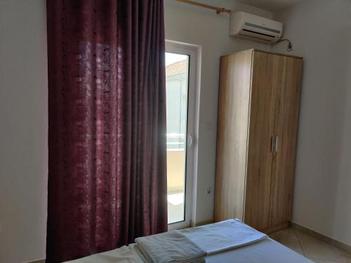 1 dormitorio con cama, ventana y vestidor en Apartments BEA, en Ulcinj