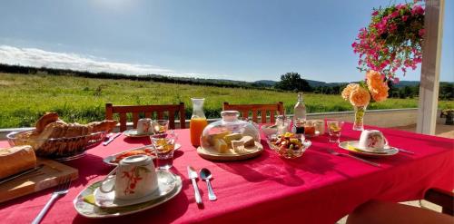 une table avec un tissu de table rouge et de la nourriture dans l'établissement A la Bonne Heure, à Pionsat