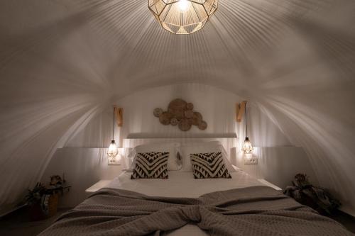 a bedroom with a large bed and a chandelier at CABO ESTE SUITES in Akrotiri