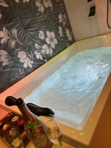 a bath tub filled with water next to a bottle of champagne at Il Gelsomino luxury suites in Bari