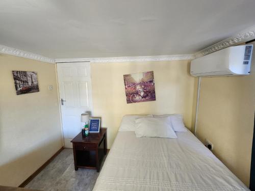 a small bedroom with a bed and a night stand at Lunar Garden Villa in Maun