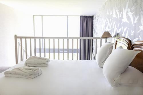 a bedroom with a white bed with white sheets and pillows at Le Relais Saint Michel in Le Mont Saint Michel