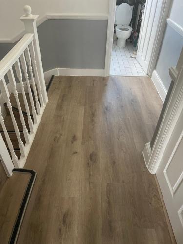 a hallway with a staircase with wooden floors and a toilet at Walpole House 2 in London