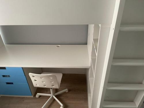 einen weißen Schreibtisch mit einem Stuhl unter einem Schreibtisch in der Unterkunft Walpole House 2 in London