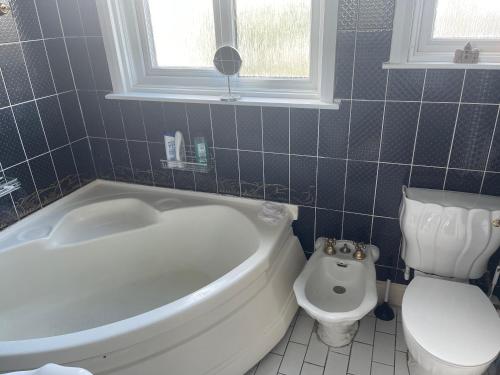 a bathroom with a white tub and a toilet at Walpole House 2 in London