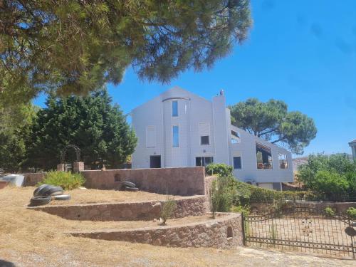 a white building with a fence in front of it at Modern Studio Apartment with Garden in Ayvalık