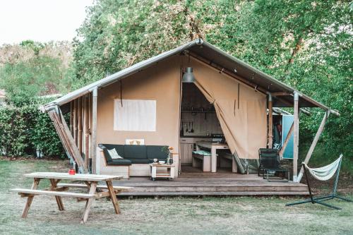 a tent with a bench and a table in front of it at Glamping Holten luxe safaritent 1 in Holten