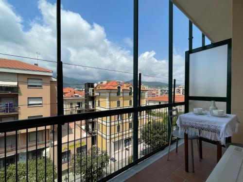 een balkon met een tafel en uitzicht op de stad bij [50 metri dal Mare] Trilocale in Centro con A/C in Loano