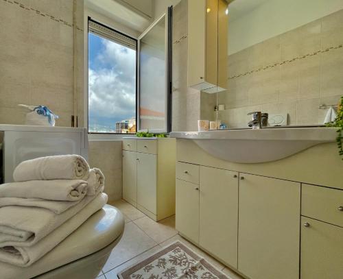een badkamer met een wastafel en een toilet met handdoeken bij [50 metri dal Mare] Trilocale in Centro con A/C in Loano