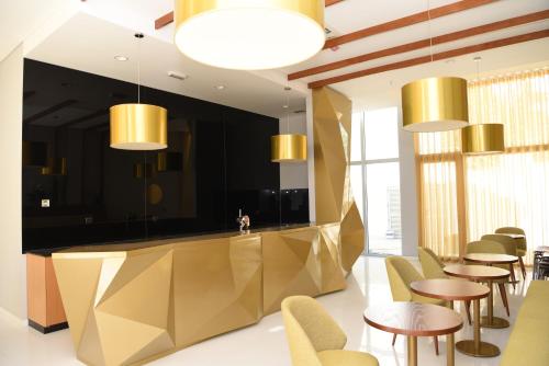 un restaurante con una barra de oro, mesas y sillas en Hotel Pedras Salgadas en Pedras Salgadas
