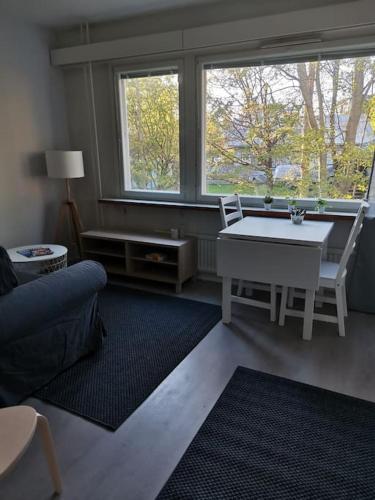 un soggiorno con tavolo, sedie e finestra di Ihana yksiö a Kokkola