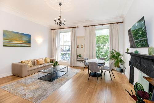 een woonkamer met een bank en een tafel bij 2-Bedroom Victorian Apartment in Kensington in Londen