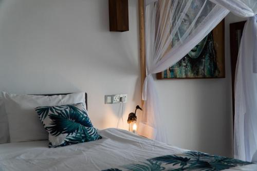 a bedroom with a bed with a pillow and a window at Visiwa Beach Resort in Watamu