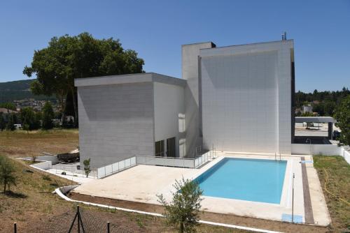 una casa con piscina frente a ella en Hotel Pedras Salgadas en Pedras Salgadas