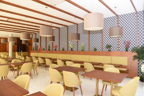 un ristorante con tavoli in legno e sedie gialle di Hotel Pedras Salgadas a Pedras Salgadas