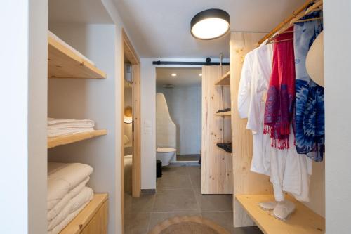 a walk in closet with wooden shelves and towels at CABO ESTE SUITES in Akrotiri