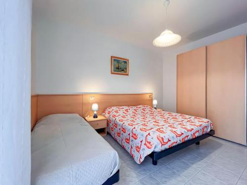 a bedroom with two twin beds and a lamp at Appartamenti Calligher in Bibione