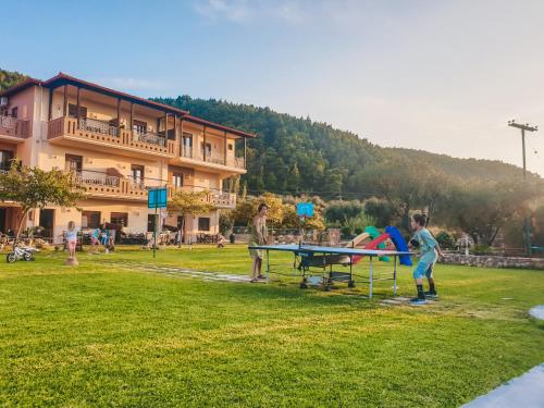 a group of people playing ping pong in a park at Aroma Studios and Apartments in Vourvourou