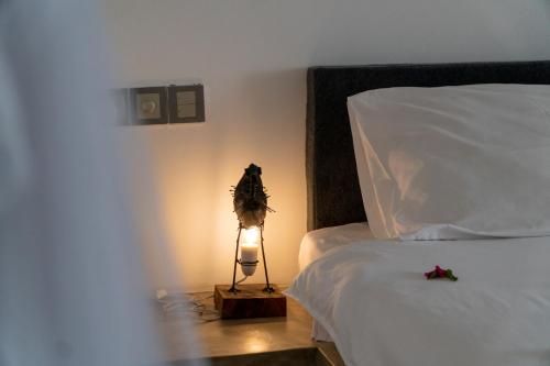 a bedroom with a bed with a lamp next to it at Visiwa Beach Resort in Watamu