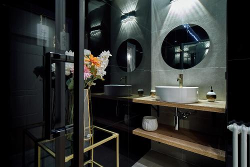 a bathroom with two sinks and two mirrors at LILIENBLUM CHIC Apartment ChicLife - Borgo Santa Caterina in Bergamo
