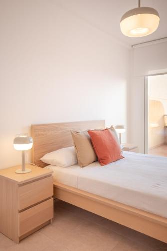 a bedroom with a large wooden bed with pillows at Casa Mediterránea in Águilas