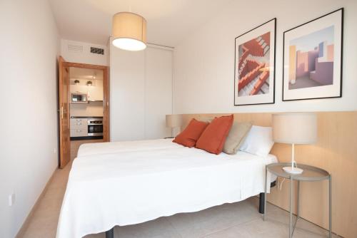 Un dormitorio con una cama blanca y una lámpara. en Casa Mediterránea, en Águilas