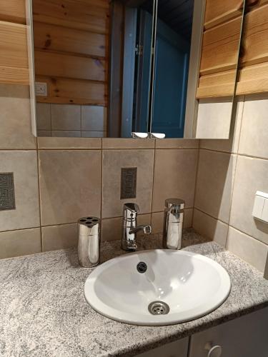 VILLA OLGA في تاكوفوري: بالوعة بيضاء في الحمام مع مرآة