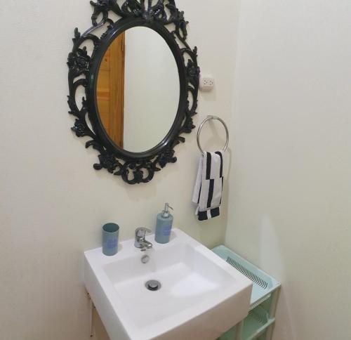 y baño con lavabo blanco y espejo. en Private and quiet room, en Jarabacoa