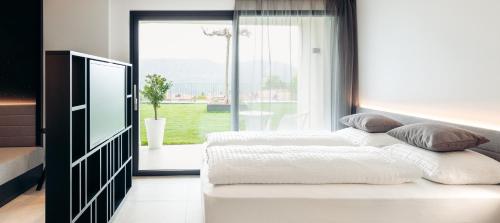 1 dormitorio con 2 camas y ventana grande en Villa Weingarten, en Caldaro