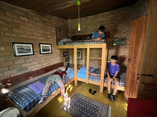 two boys sitting on bunk beds in a room at hostelvi guesthouse in Lençóis