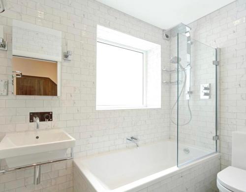 北安普敦的住宿－Cottage house，白色的浴室设有浴缸和水槽。