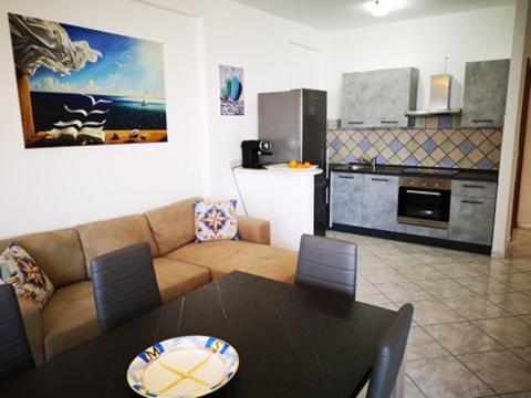 un soggiorno con divano e tavolo e una cucina di The Sail Apartment - Marzamemi a Marzamemi