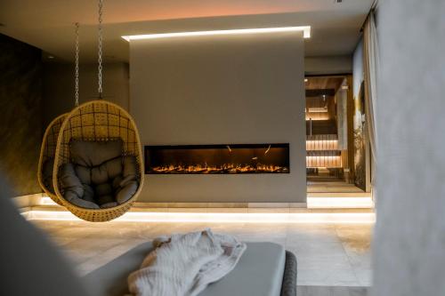 a living room with a fireplace and a couch at AlpinSpa zur Post - Bergbahn im Sommer 2025 inklusive in Bad Gastein