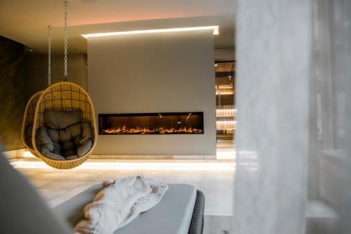a living room with a fireplace and a tub at AlpinSpa zur Post - Bergbahn im Sommer 2025 inklusive in Bad Gastein
