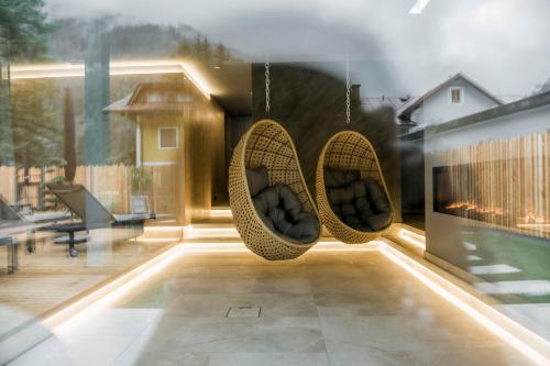 a patio with two hanging chairs on a house at AlpinSpa zur Post - Bergbahn im Sommer 2025 inklusive in Bad Gastein
