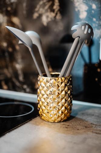 a cup filled with utensils sitting on a counter at Timeout Royal in Ellar