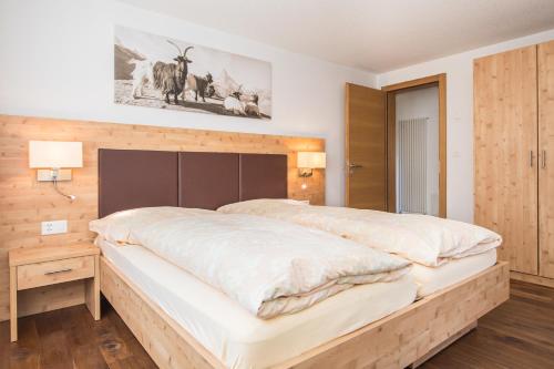 a bedroom with a large bed with a wooden headboard at Ferienhaus Felicé in Zermatt