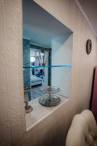 a glass shelf with two vases and a mirror at Timeout Royal in Ellar