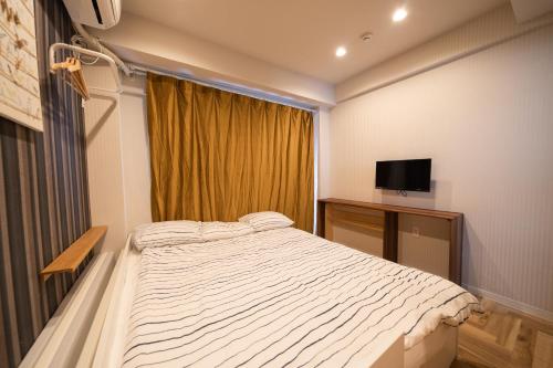 a bedroom with a large bed and a television at 池袋C1出口徒歩5分　2LDK まるまる貸切　衛生設備充実 in Tokyo