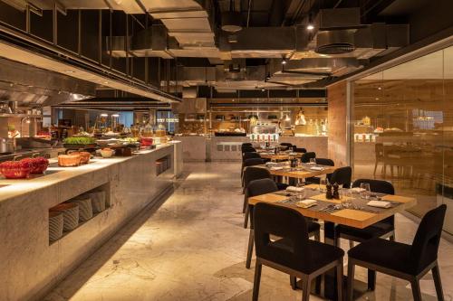 a restaurant with tables and chairs and a kitchen at Sheraton Grand Hotel, Dubai in Dubai