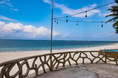 a bench on the beach with a view of the ocean at Soul Breeze Beach Resort in Diani Beach