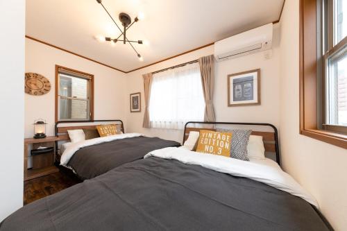 twee bedden in een kamer met twee ramen bij Sumida Ward - House - Vacation STAY 89066 in Tokyo