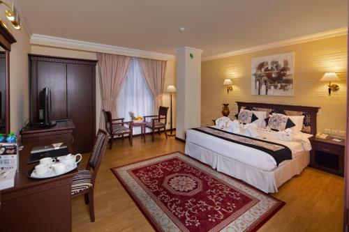 a hotel room with a bed and a table and chairs at Pars International Hotel in Manama