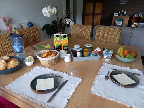 drewniany stół z talerzami i miskami z jedzeniem w obiekcie Chambre 2 lits simples - Spa w mieście Spa