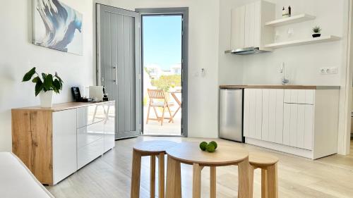 a kitchen with a table and some chairs in it at Anita Rooms & Suites Milos in Adamas