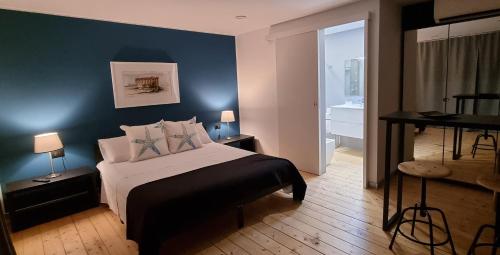 ein Schlafzimmer mit einem Bett und einer blauen Wand in der Unterkunft La Maison della Valle in Agrigento