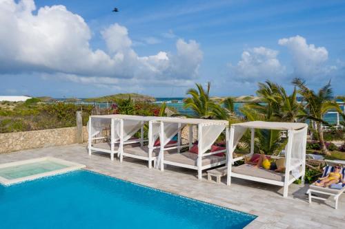 a resort with a pool and chairs and the ocean at Visiwa Beach Resort in Watamu